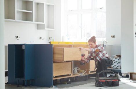 a girl kitchen fitter prepping cupboards for worktop