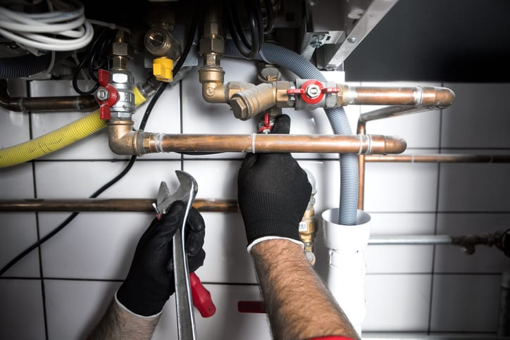 A man tightening some pipes