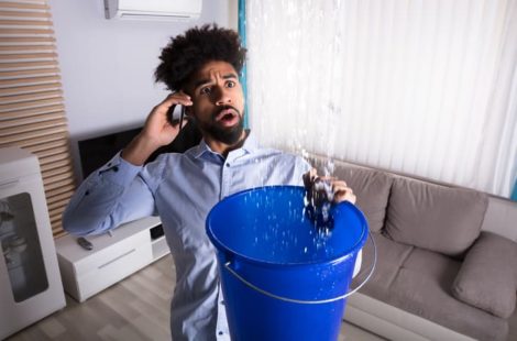 a man with a bucket collecting leaking water