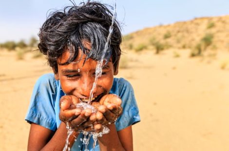 a boy drinking water from his hands