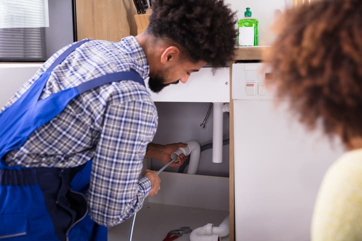 The plumber fixing a clogged pipe in washing sink, WA