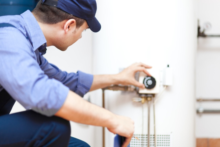 Technician adjusting water heater in Seattle home
