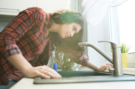 Woman inspecting sink faucet