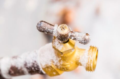 A Pipe spout with snow covering it.