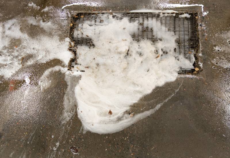 Clogged floor grate with dirty soap