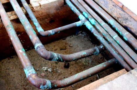 A close-up of corroded copper pipes