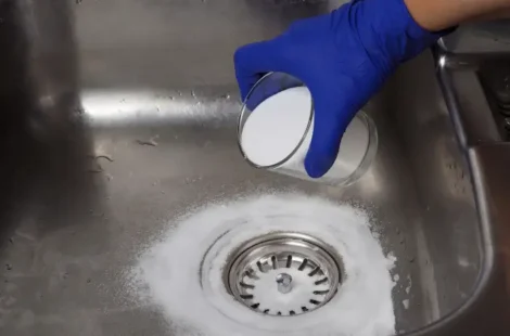 A person using a homemade drain cleaner to unclog their drains