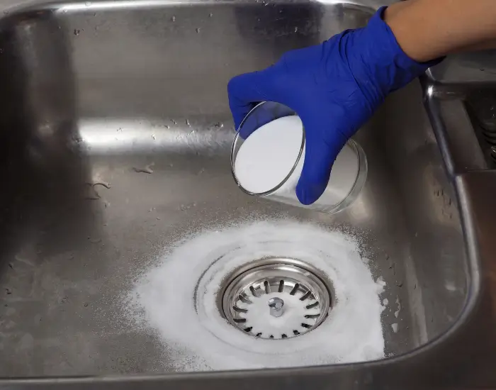 A person using a homemade drain cleaner to unclog their drains