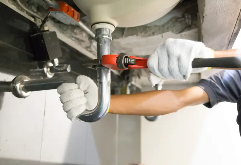 A person performing plumbing maintenance services in Seattle, Washington